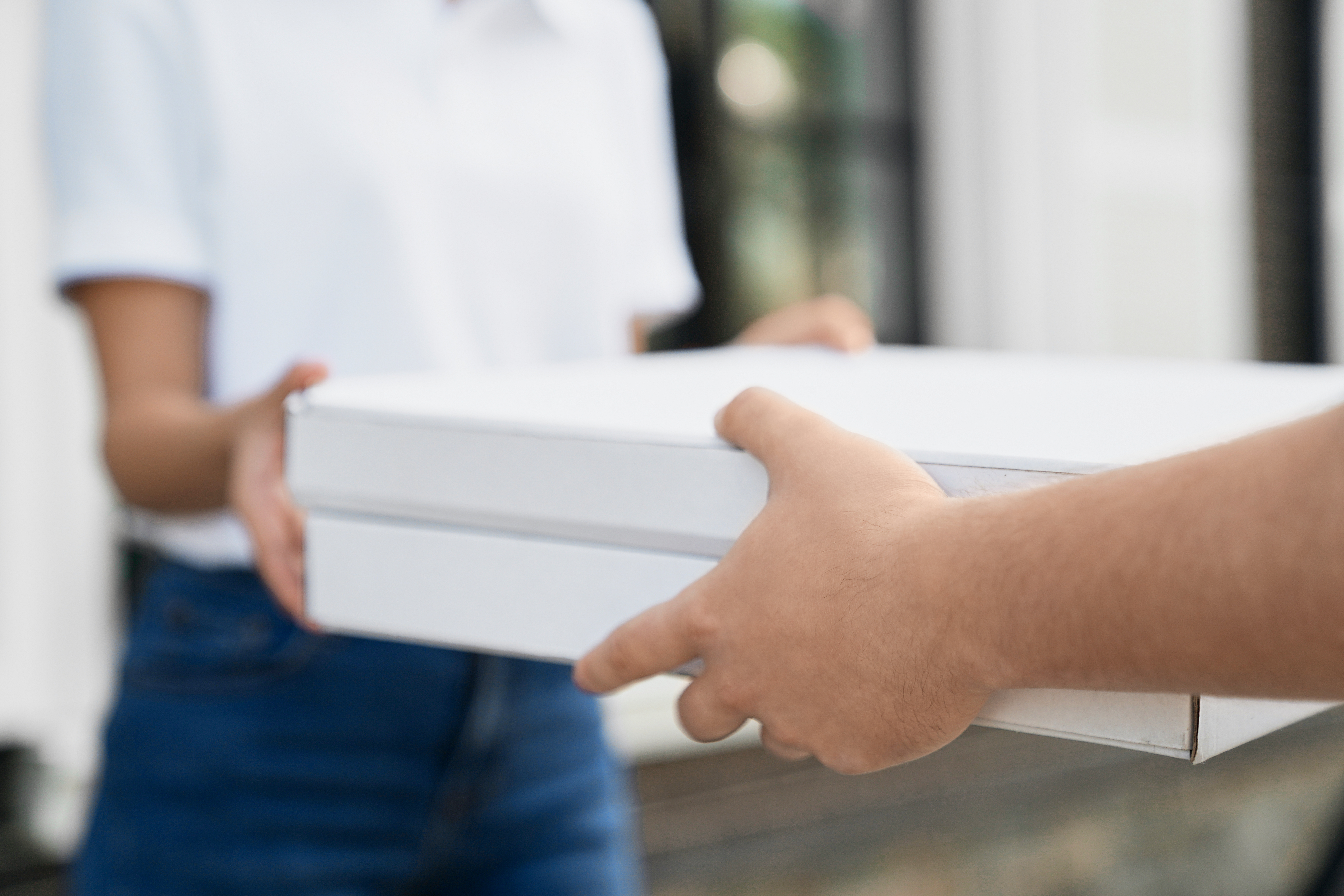 Pessoa recebendo caixa de entrega em casa, representando logística e envios estratégicos