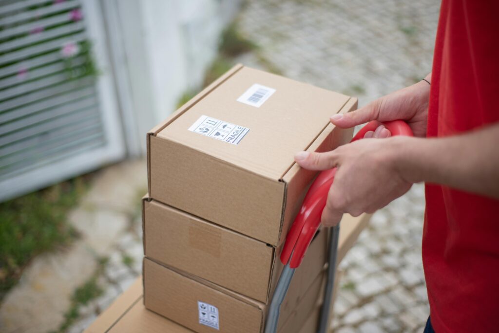 Caixas de entrega sendo transportadas para envio ao cliente, representando logística e planejamento de vendas